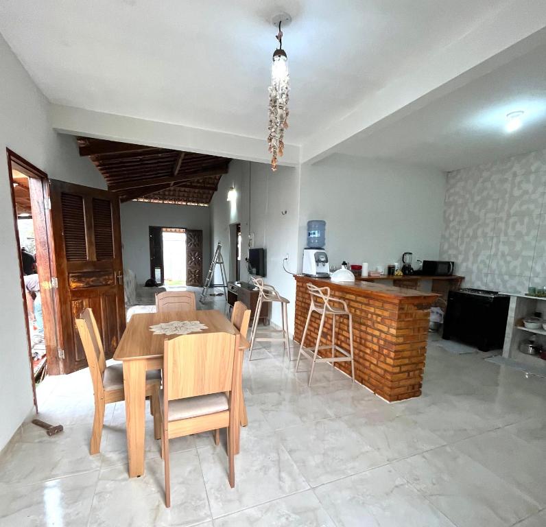 a dining room and kitchen with a table and chairs at Casa por do sol Flecheiras in Flecheiras