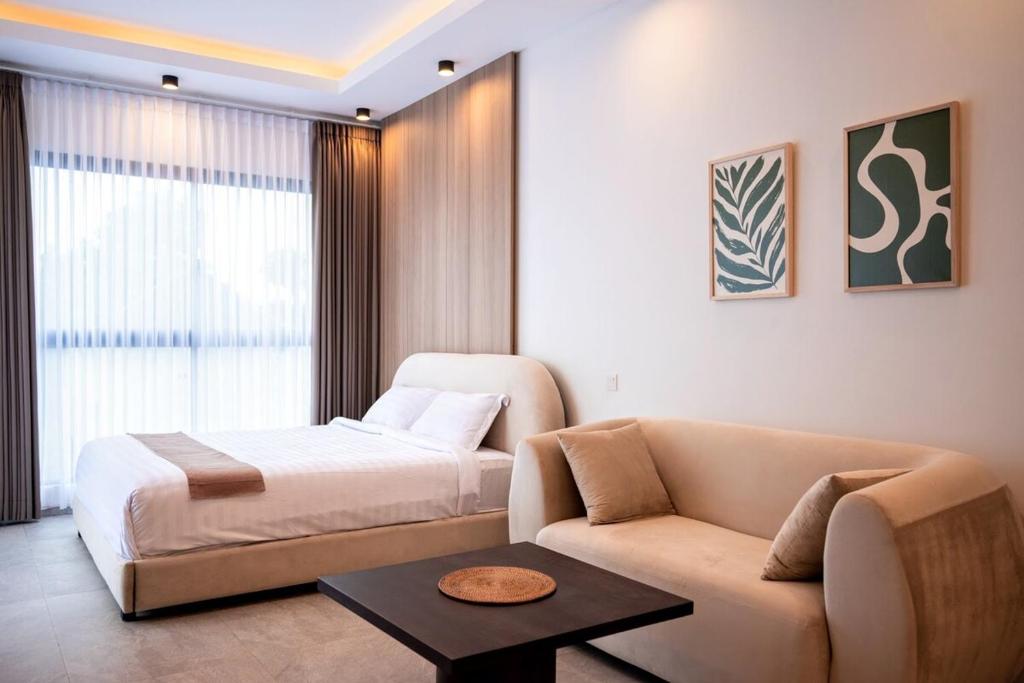 a hotel room with a bed and a couch at Villa Nuansa in Mantaak