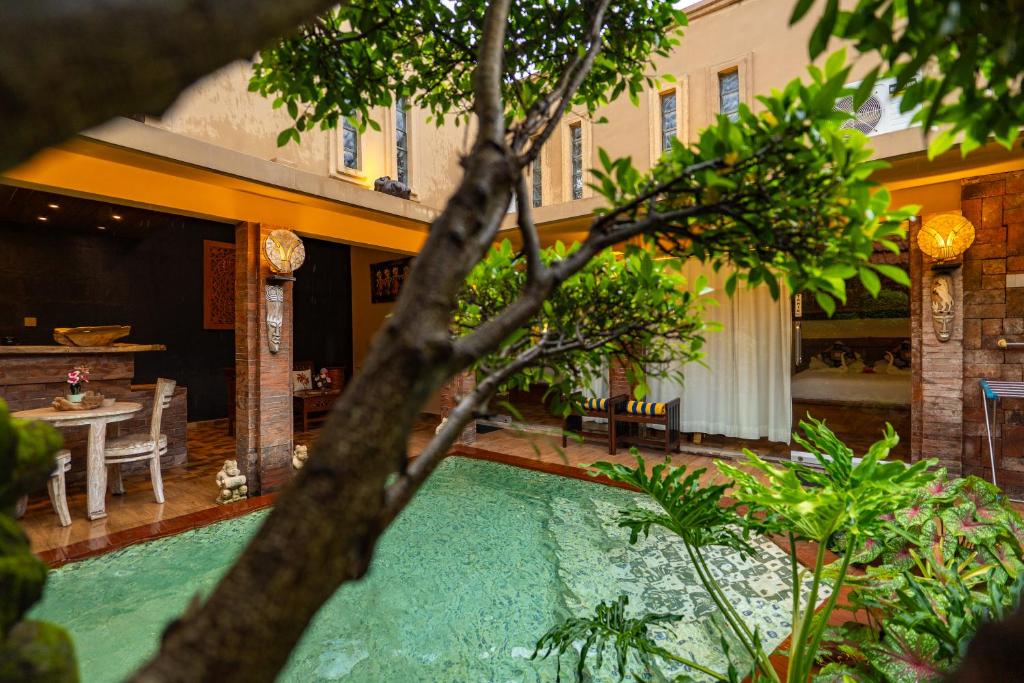 a swimming pool in the middle of a house at Sajjana House Nusadua By Magno in Nusa Dua