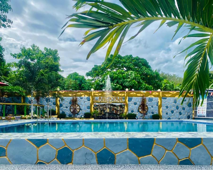 a swimming pool at a resort with a fountain at Landayan Traveller Inn in Baco Medio Island