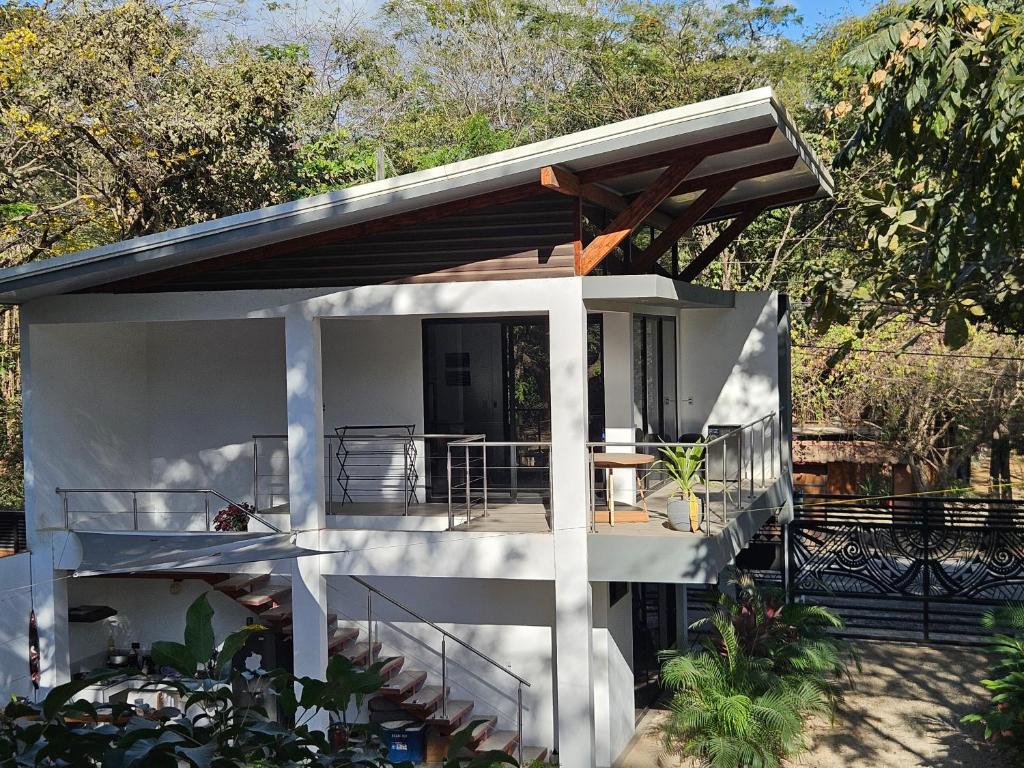a small white house with a porch and a patio at Mystica in Playa Avellana