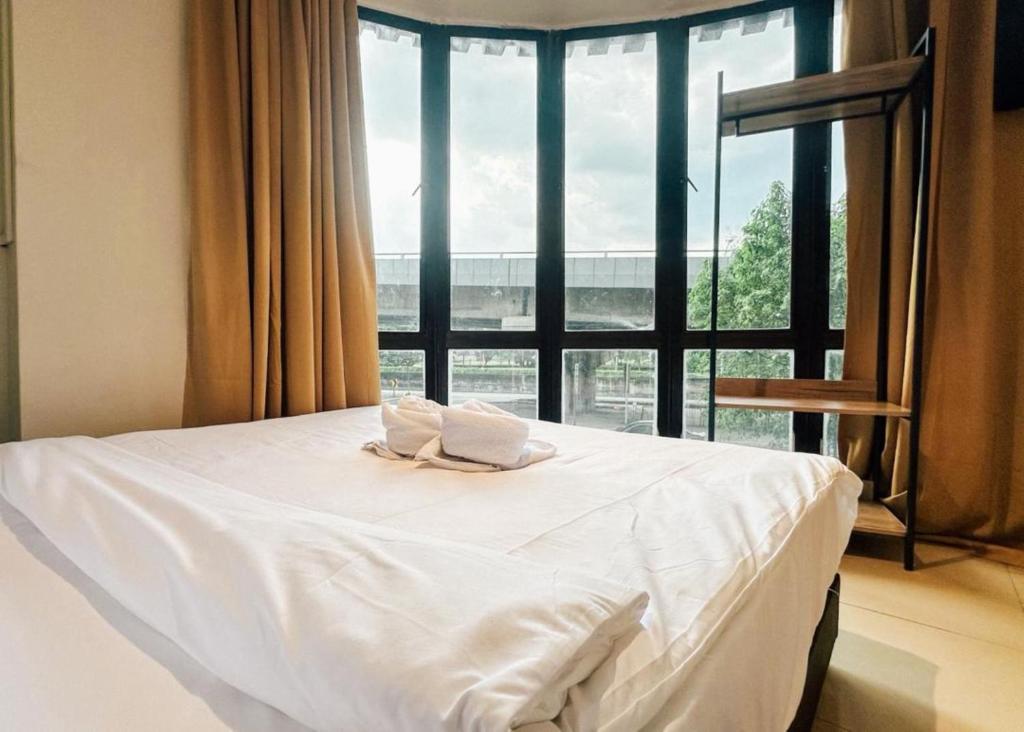a bed in a room with a large window at Swing & Pillows - Sentul Jalan Ipoh Kuala Lumpur in Kuala Lumpur