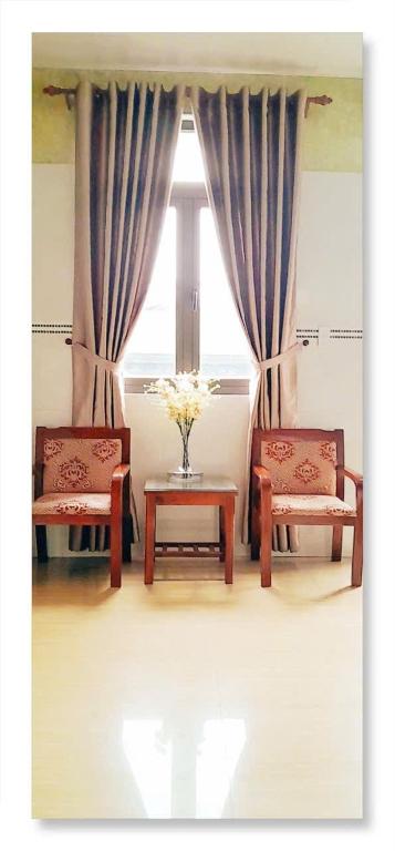 a room with two chairs and a table and a window at LUNA House in Hue