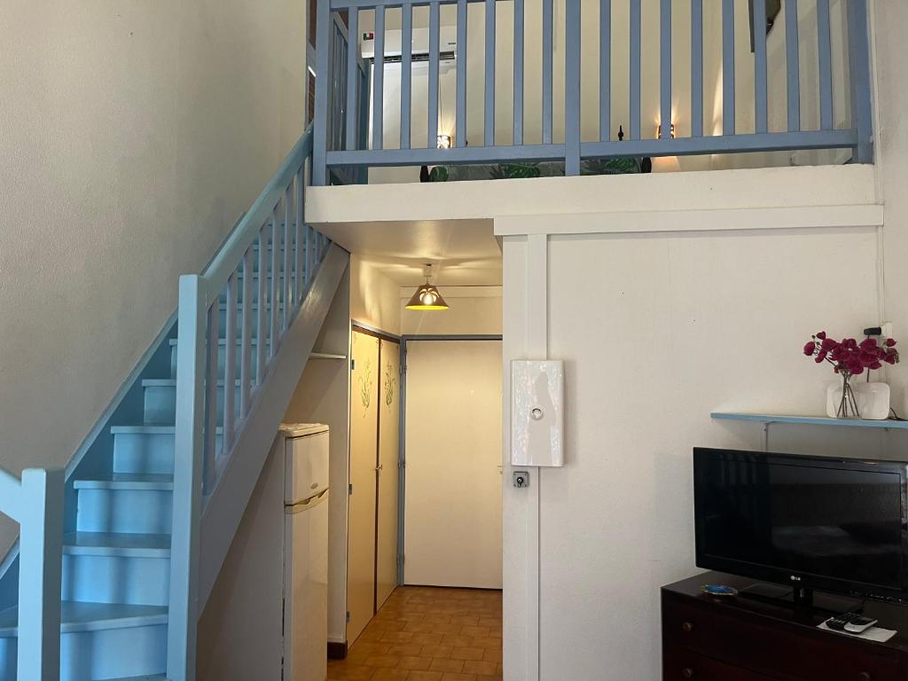 a hallway with a staircase with a blue stair case at APPARTEMENT LOTUS avec PISCINE et à 3 min de la PLAGE Pointe Marin in Sainte-Anne