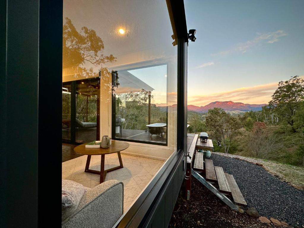 a glass house with a view of the mountains at Hilltop Haven Darlington in Darlington