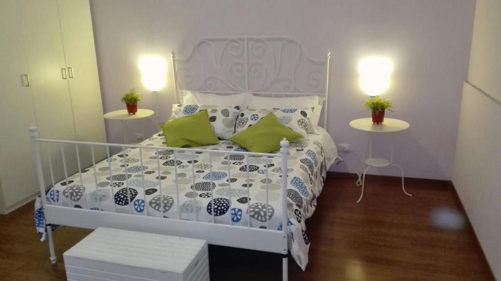 a white bed in a small room with two tables at Una Piacevole Sorpresa in Bari