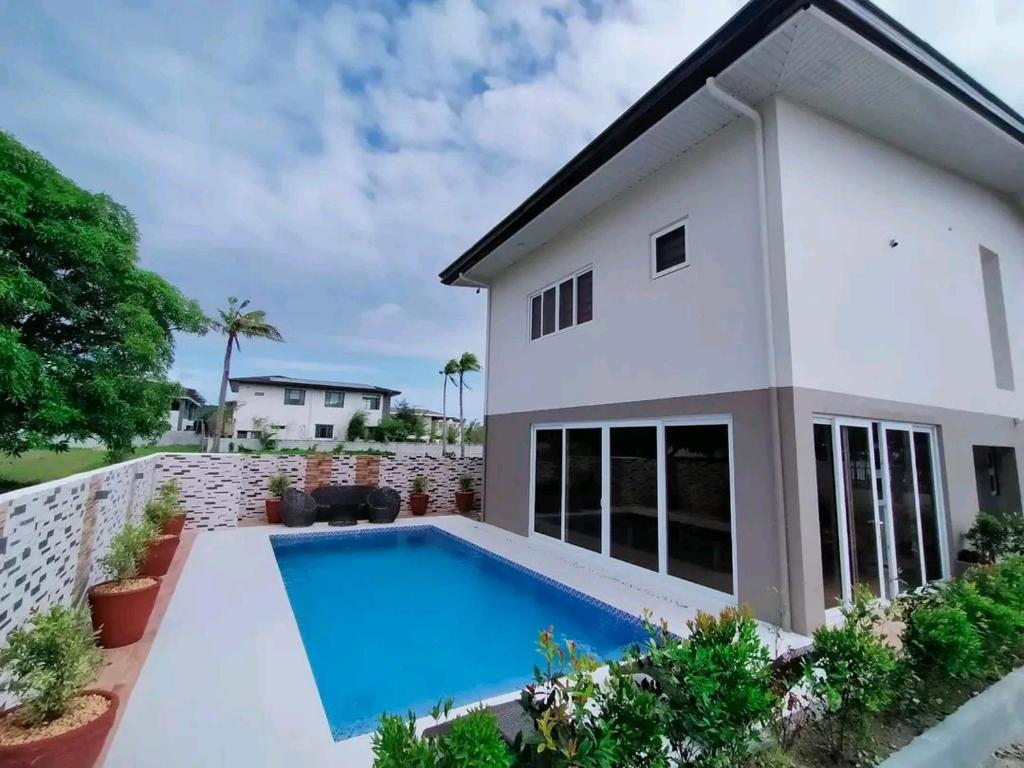 a house with a swimming pool in front of it at Beachfront With 2 Bedrooms and Pool for 20 in San Juan