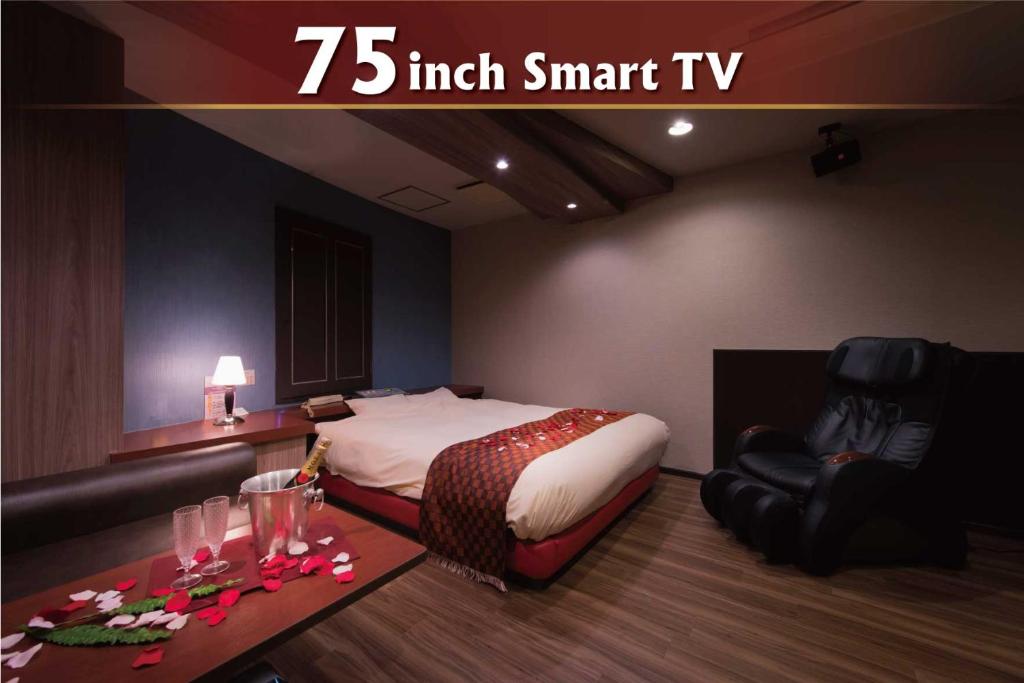 a bedroom with a bed and a chair and a table at Hotel Will池袋 Adult Only in Tokyo
