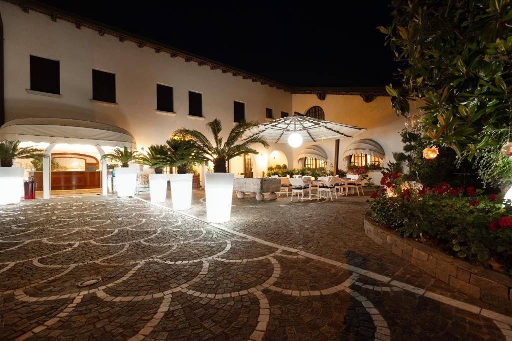 a courtyard of a building with a table and chairs at Hotel Prata Verde in Prata di Pordenone