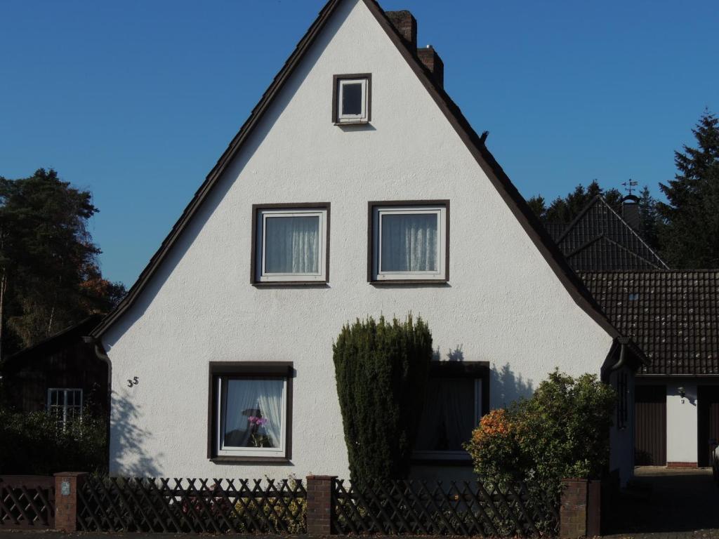 una casa blanca con techo negro en Ferienhaus Snevern, en Schneverdingen