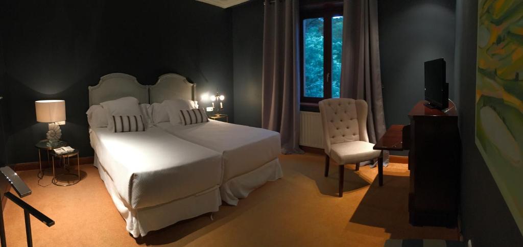a bedroom with a white bed and a window at Hotel Etxeberri in Zumárraga