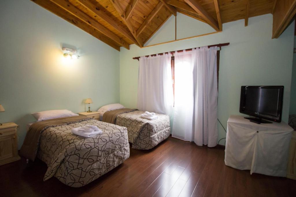 a room with two beds and a tv in it at Isla Bella in Ushuaia