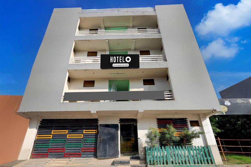 a white apartment building with a sign on it at Super Hotel O Dadri Main Road Greater Noida in Greater Noida