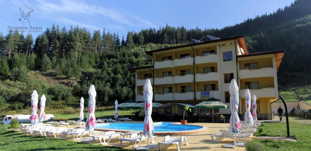 a hotel with a bunch of chairs and a pool at Hotel Restaurant Popini Laki in Yagodina