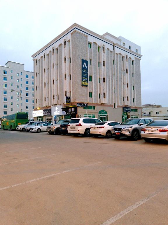 a parking lot with cars parked in front of a building at أجاويد 1 Ajaweed in Salalah