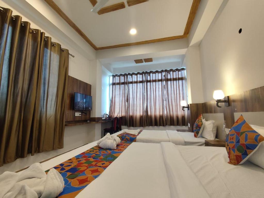 a hotel room with two beds and a television at HOTEL GREENERY VIEW in Gangtok