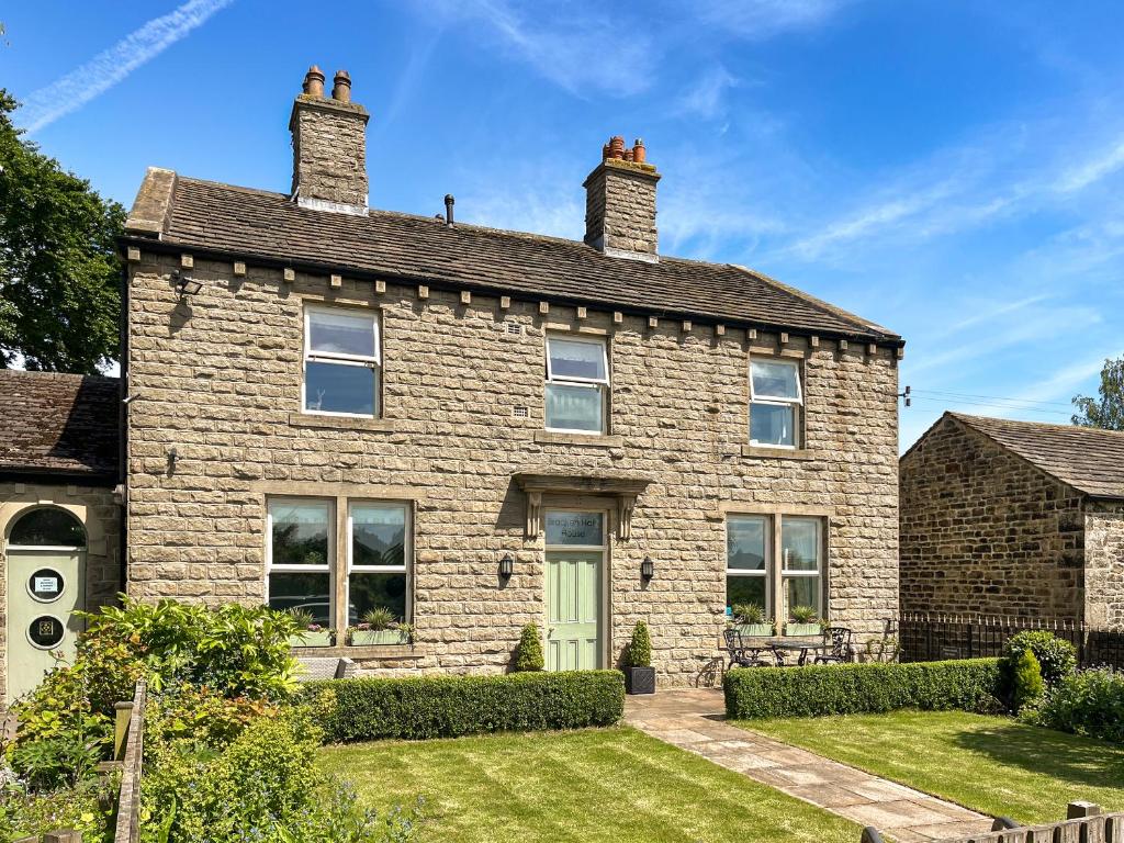 an old brick house with a green door at Bracken Hall House in Baildon
