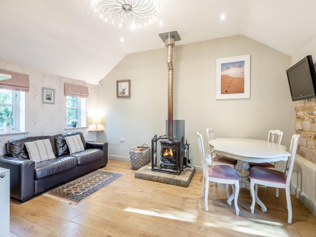 a living room with a couch and a table and a wood stove at Walnut Cottage - Ukc6632 in Pentney