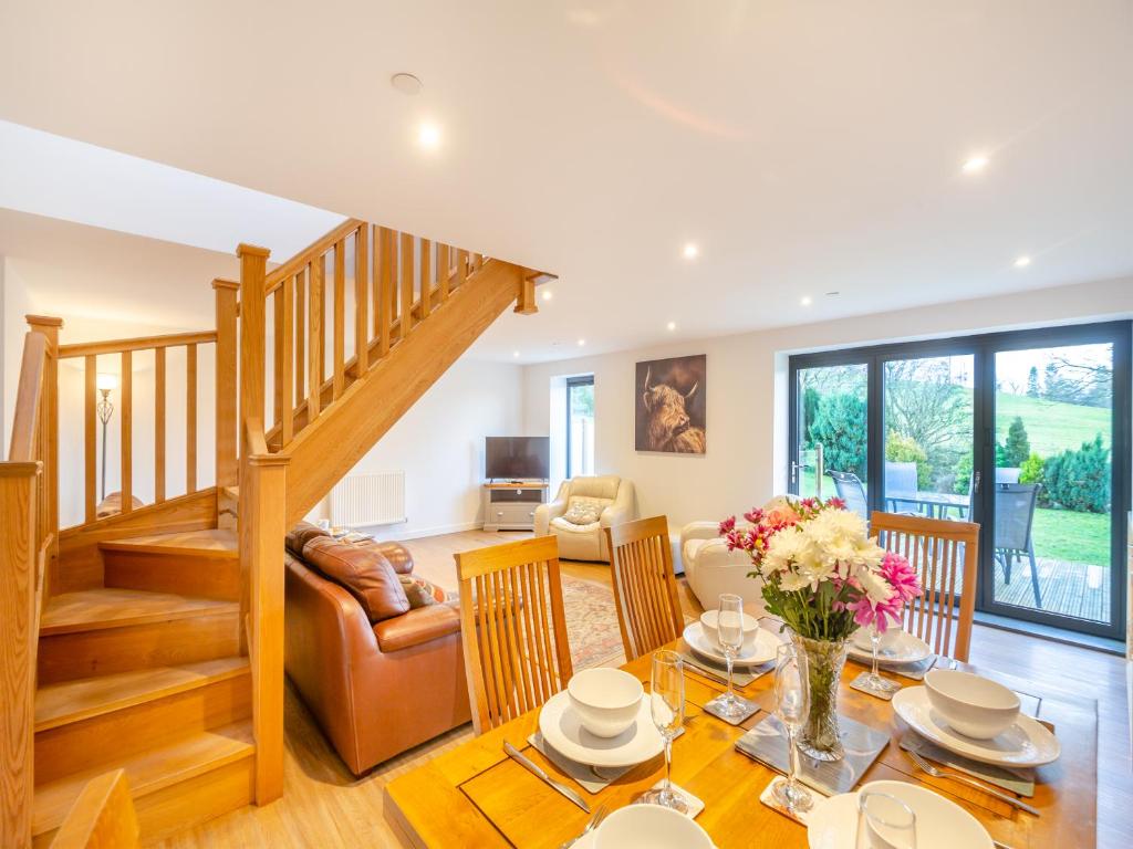 a living room with a table and chairs and a staircase at Arenig View - Uk51068 in Frongoch