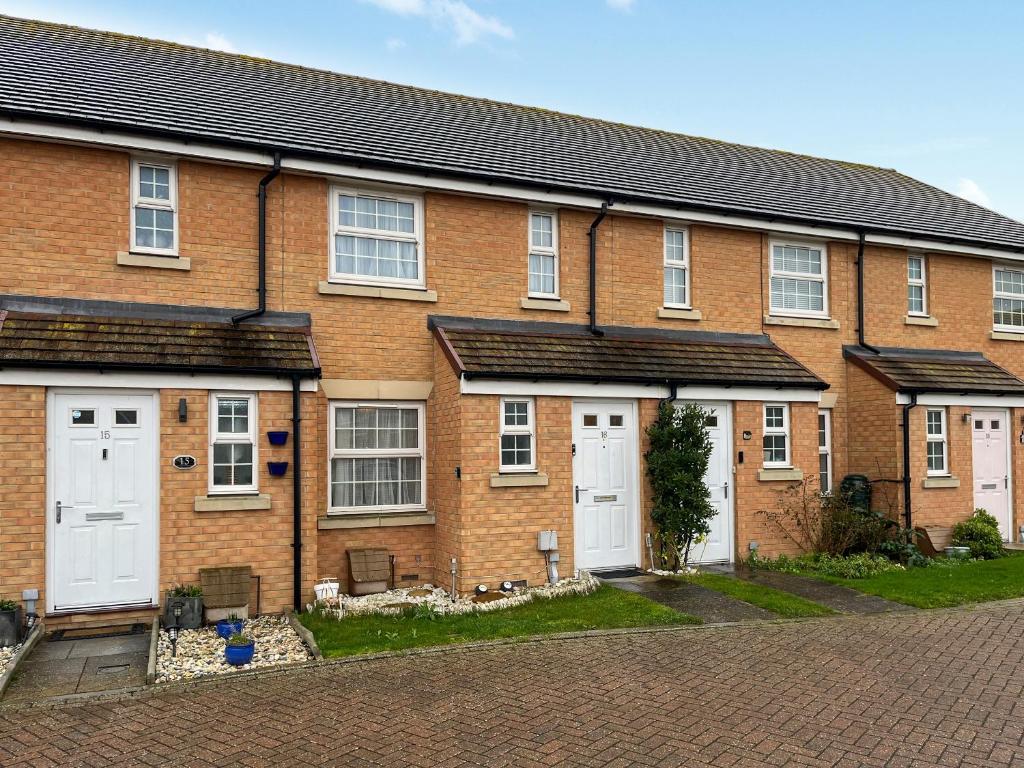 a brick house with white doors on a street at Richborough House in Saint Peters