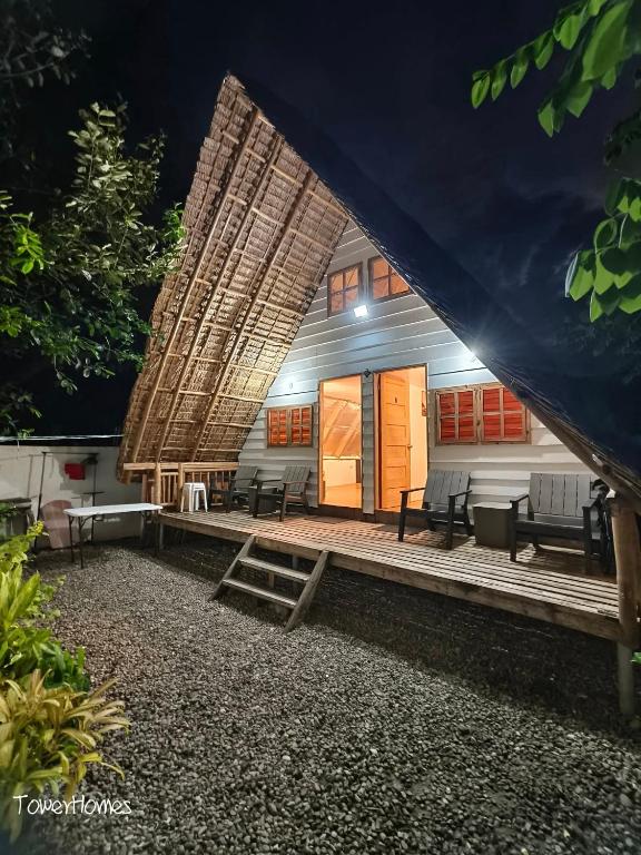 a building with a porch with benches and a tent at Duplex B- Seaside Haven Transient Inn at Caba, La Union in Caba
