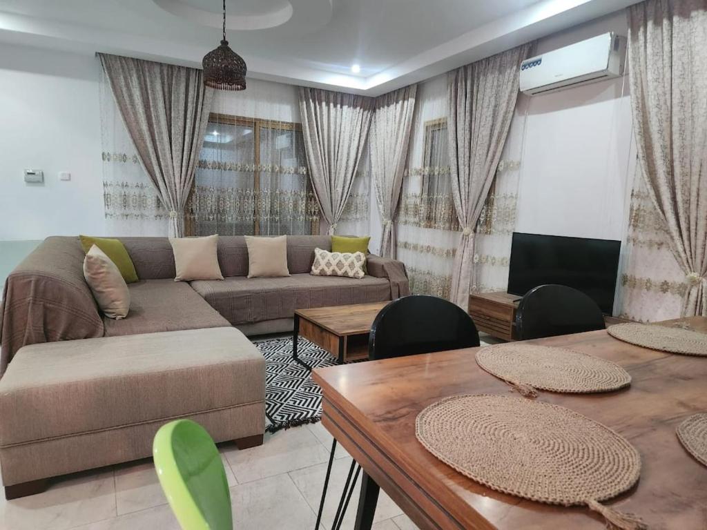a living room with a couch and a table at Jasmin Prestige Duplex - Hammamet in Hammamet