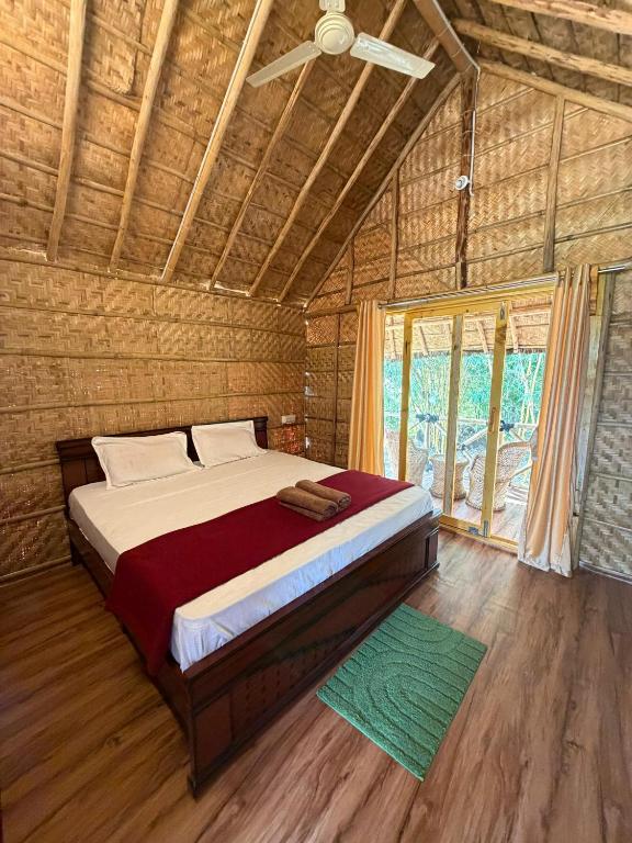a bedroom with a bed in a room with a window at Monkey Paradise Hampi in Hampi