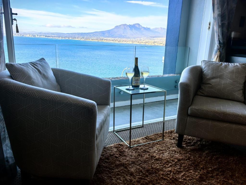 a living room with a couch and a table and a window at Boutique Inn - Quintessence in Gordonʼs Bay