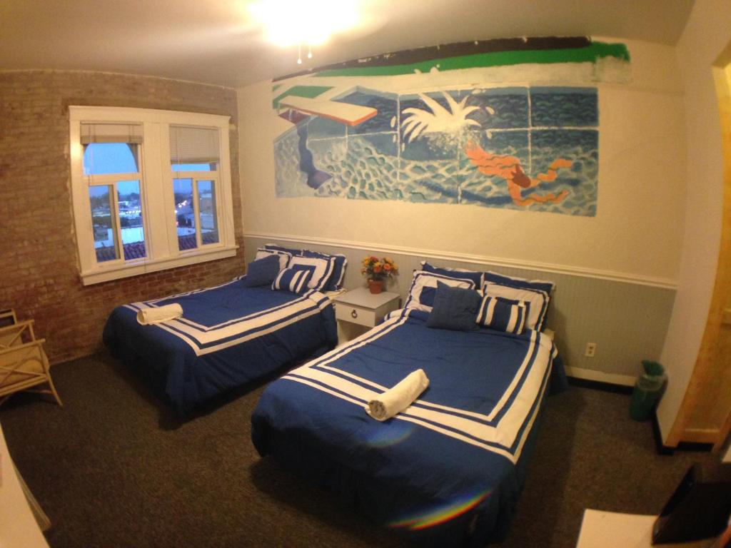 a bedroom with two beds and a painting on the wall at Venice Beach Hostel in Los Angeles