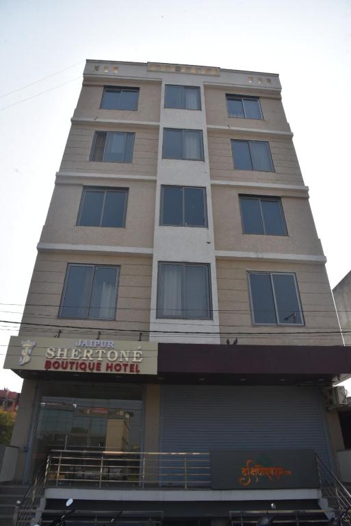 a tall building with a sign on it at Hotel Jaipur Shertone in Jaipur