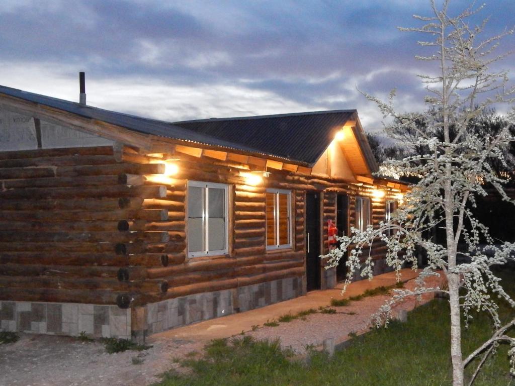 a log cabin with lights on the side of it at Complejo Alma Serrana in Sierra de la Ventana