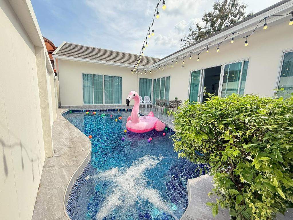 a swimming pool with a pink flamingo in a house at Buddy pool villa in Nong Prue