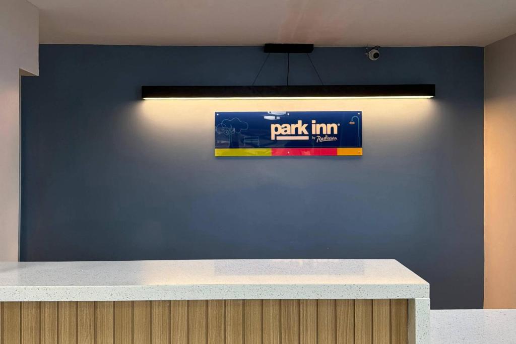 a blue wall with a sign on a wall at Park Inn by Radisson, Weldon - Roanoke Rapids in Weldon