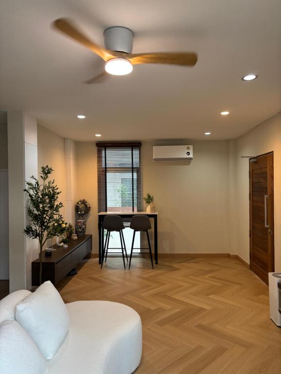 a living room with a ceiling fan and a table at Vanilla Villa in Ban Yep Chaeng