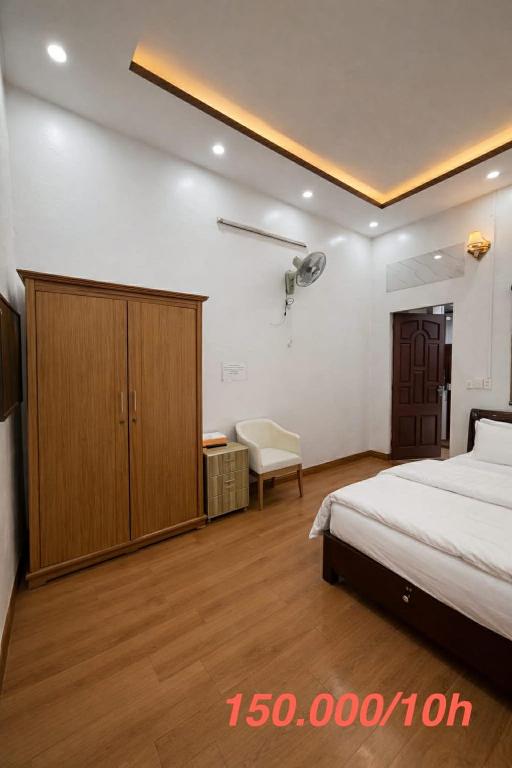 a bedroom with a bed and a cabinet and a chair at Phong Khánh Hostel in Than Uyên