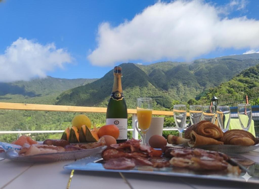 a table with a plate of food and a bottle of champagne at Le Lys des Makes in Saint-Louis