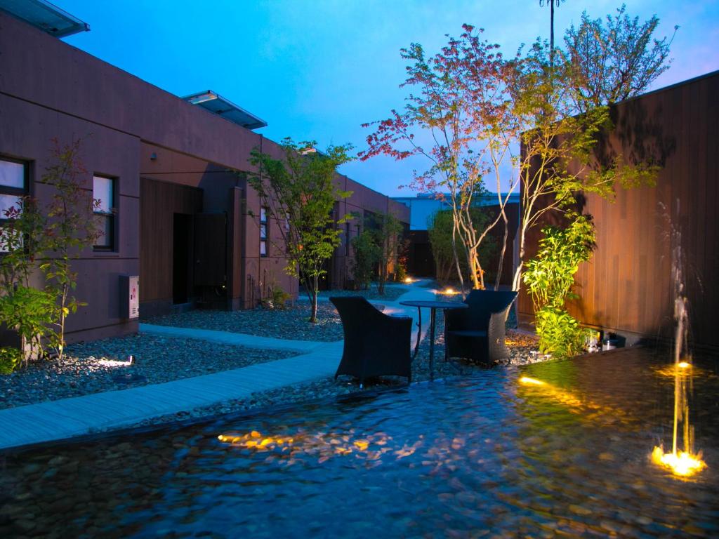 ein Innenhof mit Tisch und Stühlen und einem Brunnen in der Unterkunft 大分温泉 Business Resort Sourin in Ōita