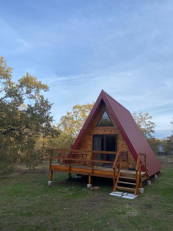 a small log cabin with a red roof at El Roble Glamping - Cabaña Alpina Familiar in Lagunilla