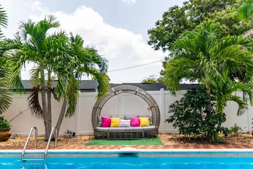 a wicker bench with colorful pillows sitting next to a pool at Pink Flamingo in Clearwater