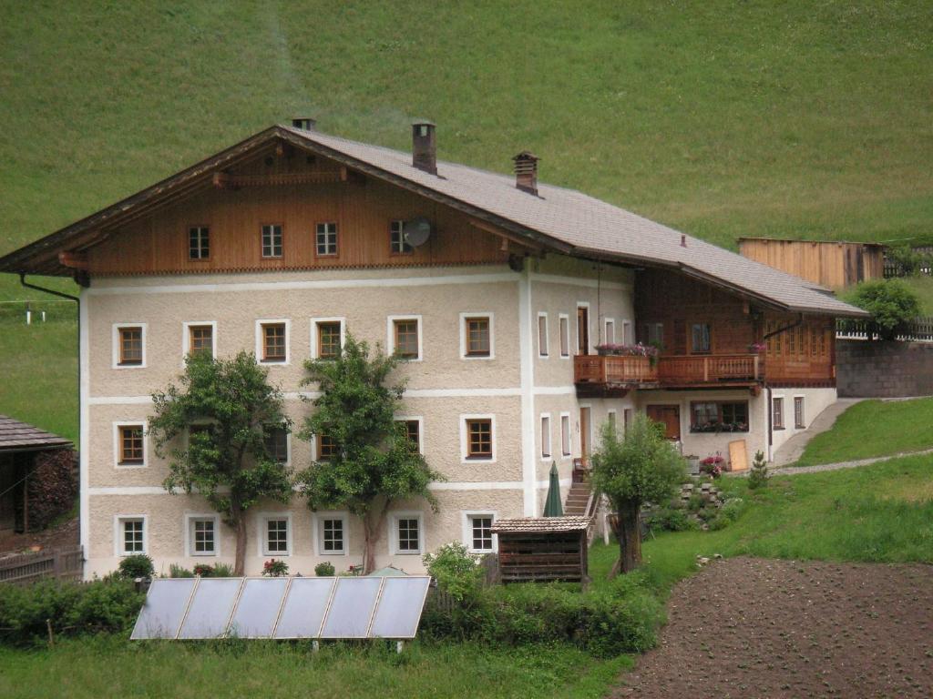 a large white house with a wooden roof at Ferienwohnung Innerlipper in Innervillgraten