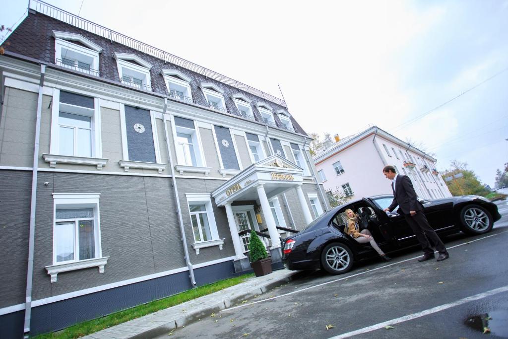 a man is stepping out of a car at Premium Hotel Pushkin in Angarsk