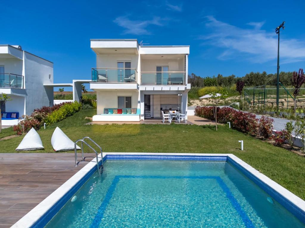 a villa with a swimming pool and a house at Sani Beverly Hills Luxury Villas in Sani Beach