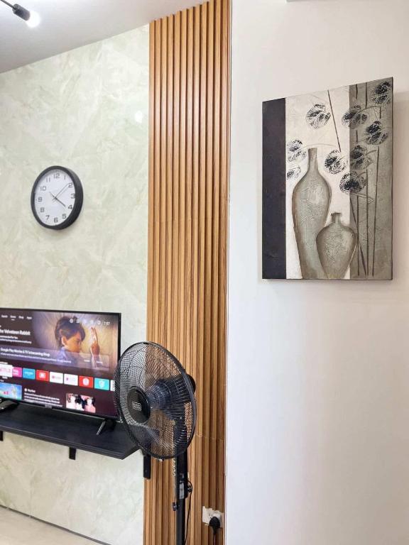 a room with a tv and a clock and a fan at Chic Urban Escape at S Residence Tower 3 in Manila