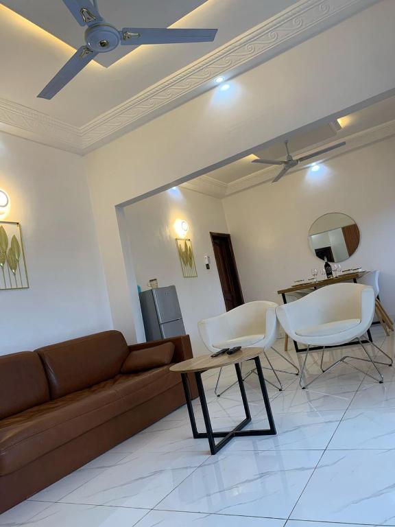 a living room with a couch and chairs and a table at 2 chambres salon au calme in Porto-Novo