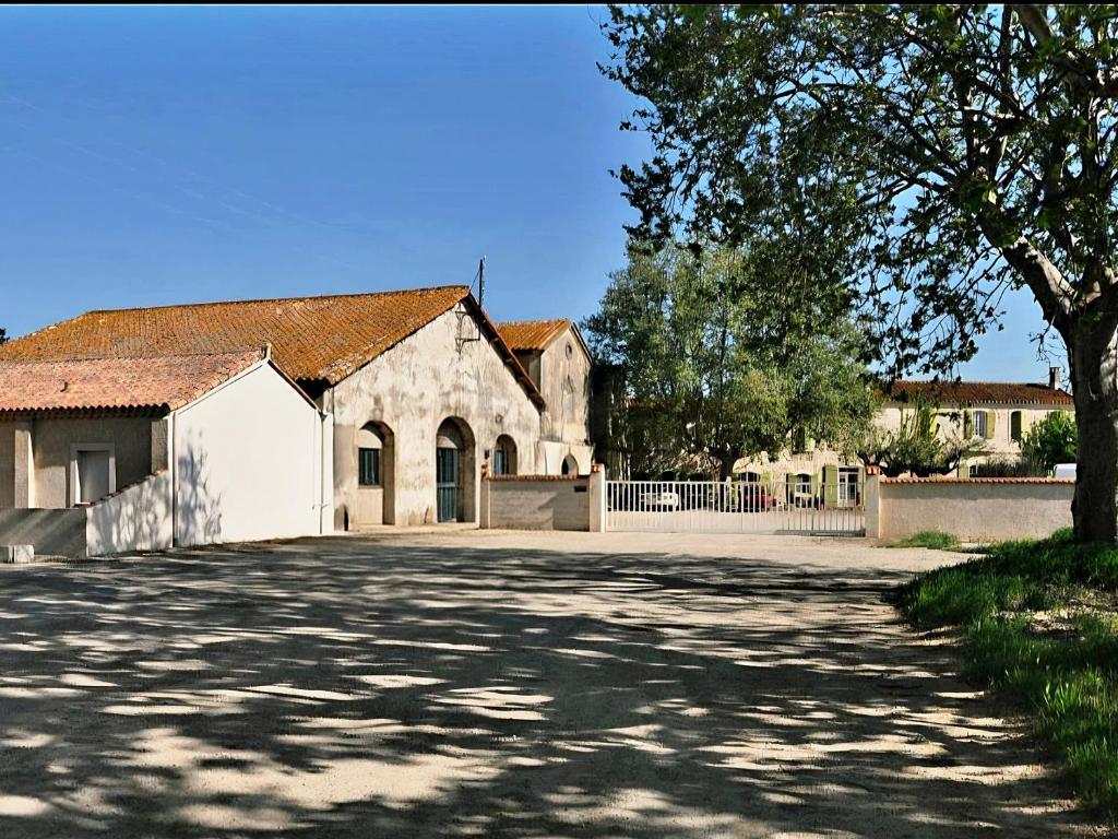 un grande edificio bianco con un albero e un vialetto di Le HERON a Arles