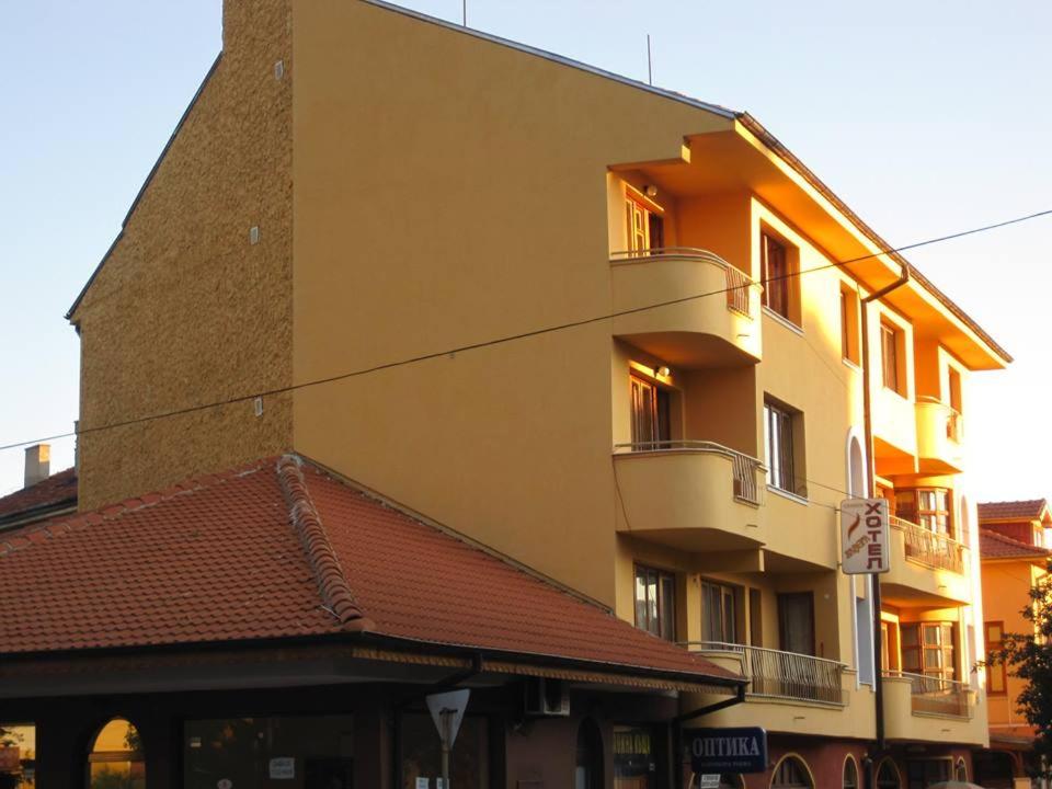 a large yellow building with a red roof at Hotel Lavega in Kyustendil