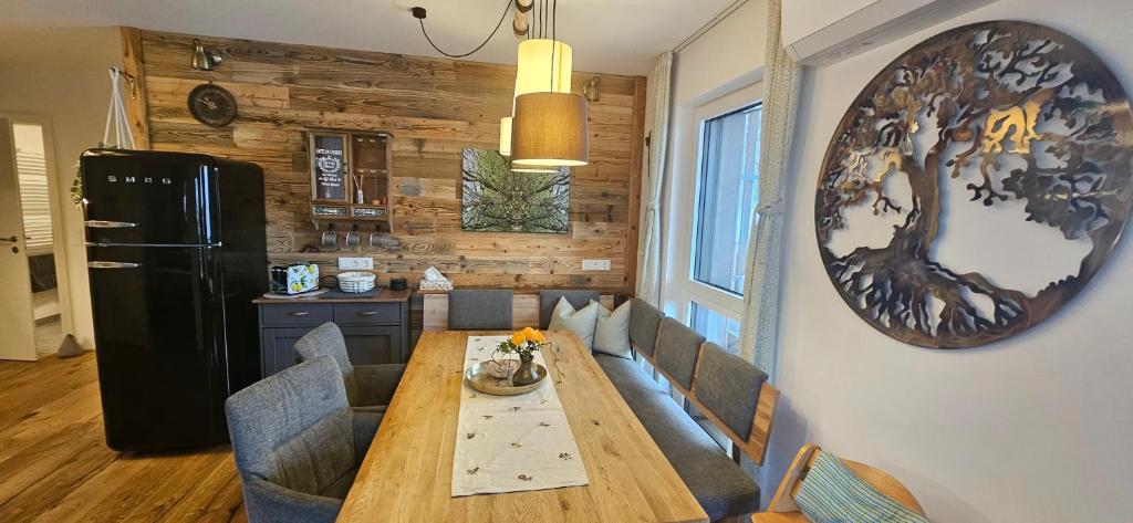 a dining room with a table and a refrigerator at Seensucht Klopeinersee in Sankt Kanzian