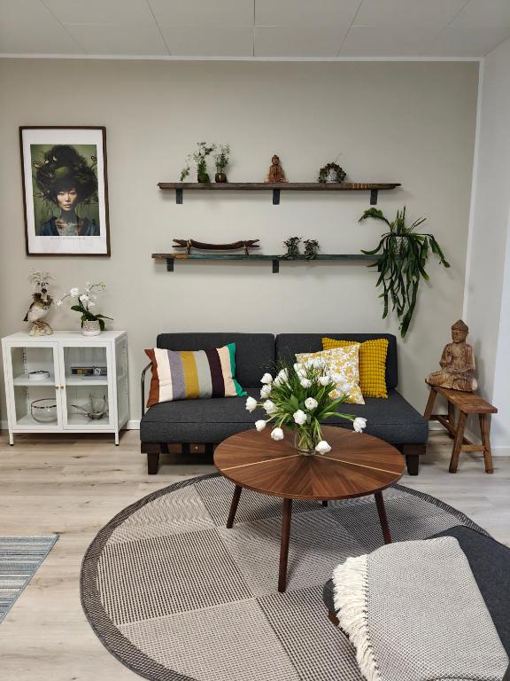 a living room with a couch and a table at Eksklusiv villalejlighed m/ have in Holme
