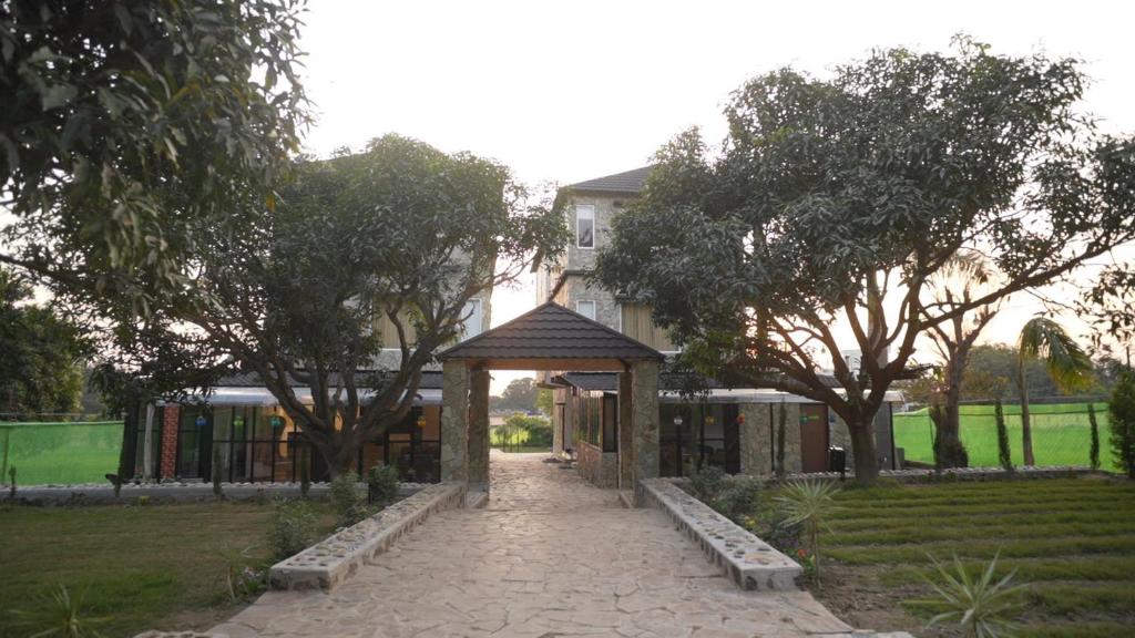 a gazebo in front of a house with trees at Ramjay Corbet Jungle Resort in Kotdwāra