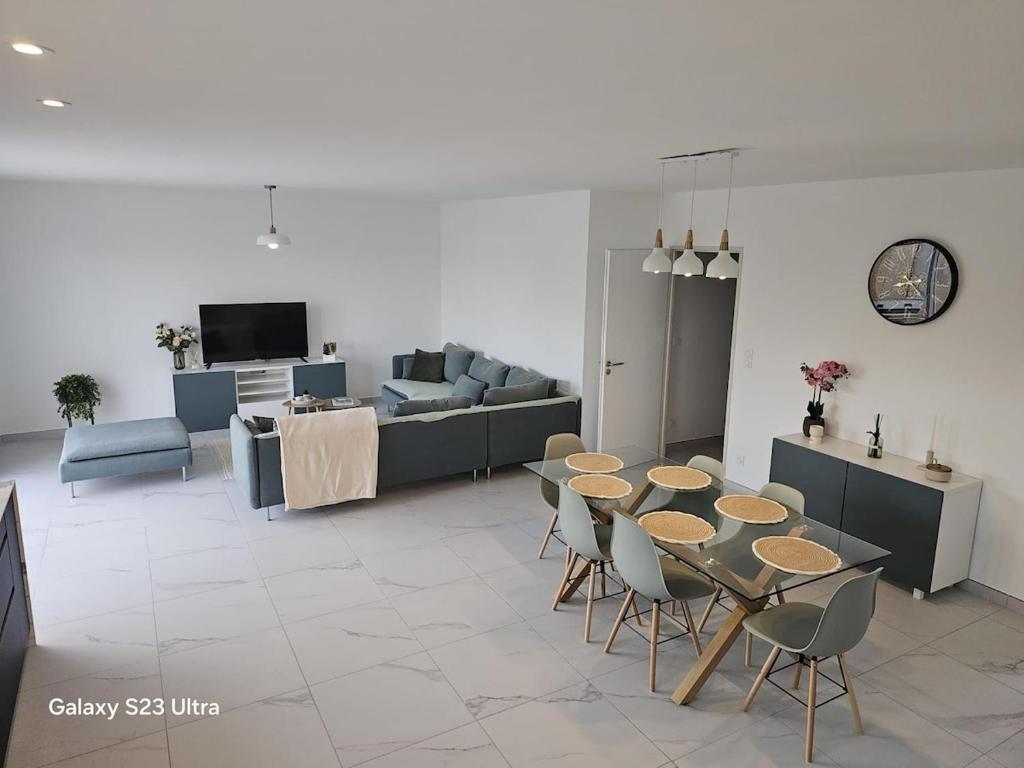 a living room with a table and chairs and a couch at Relax & work à Frespech 3 chambres 6 personnes in Frespech